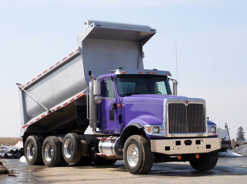 Purple International dump truck with raised bed at a work site