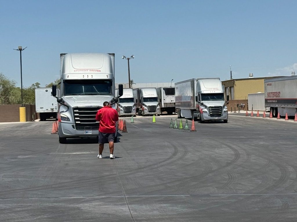 CDL instructor directing multiple student drivers through a cone course during Class A truck driver training at Southwest Truck Driver Training
