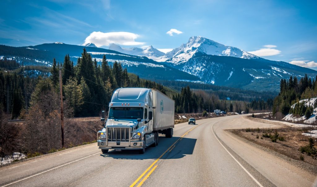 truck driving up the hill with mountains in background, how the transportation industry has changed,trucking transportation