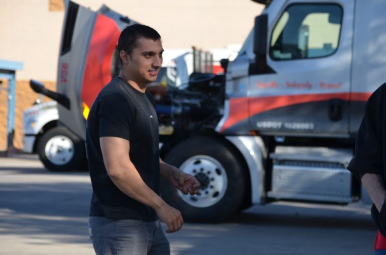 CDL student in the yard at Southwest Truck Driver Training with semi-trucks in the background