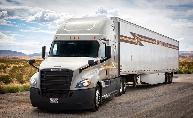 May Trucking Company Freightliner semi-truck on a desert highway
