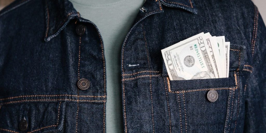 Cash in a denim jacket pocket