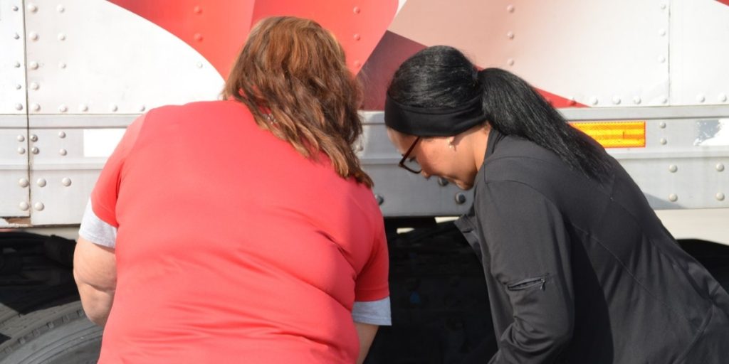 Two women performing a pre-trip truck inspection during CDL training at Southwest Truck Driver Training