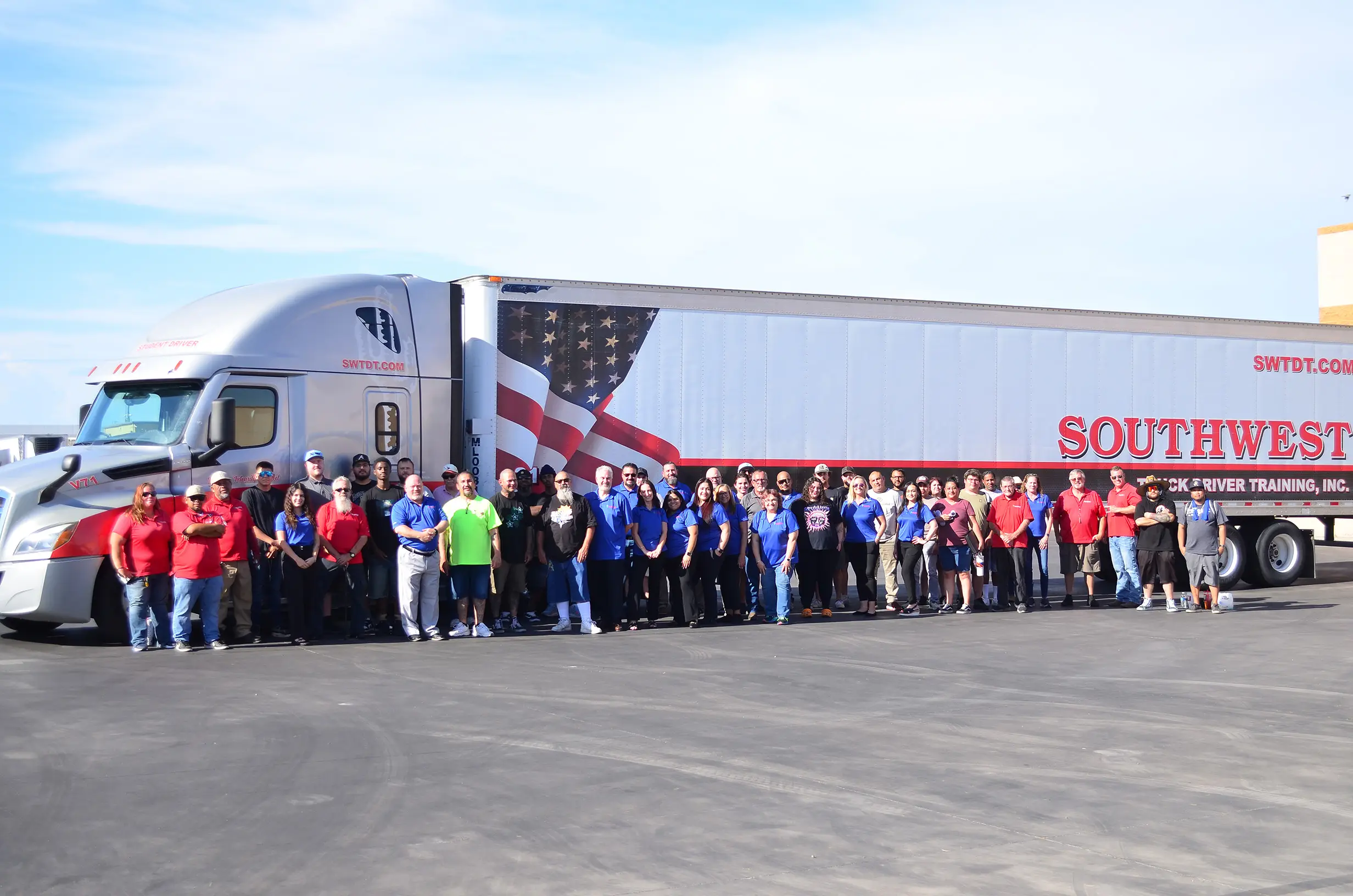 Large group of SWTDT students and team posed in front of semi truck
