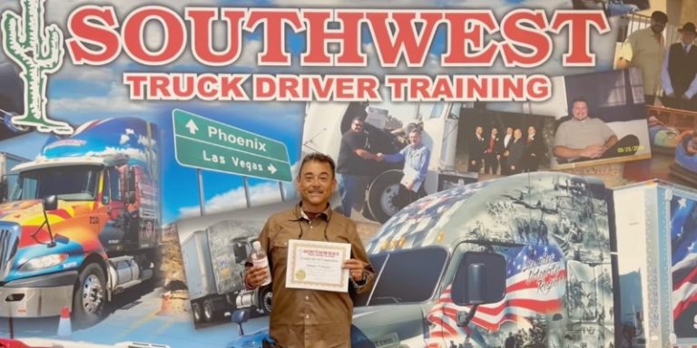 Jimmy holding up his certificate in front of the Southwest background